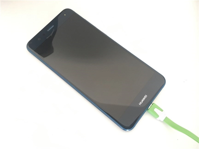 An Android smartphone connected to a USB cable