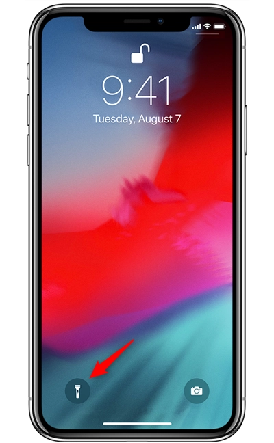 The flashlight button on the lock screen of an iPhone X