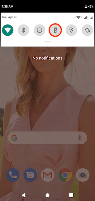 The Flashlight button in the compact view of Quick settings