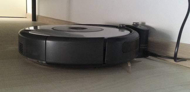 The Roomba docked safely in its Home Base under the bed