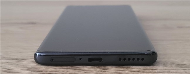 The bottom edge includes the USB port, a microphone, a speaker, and the SIM card slot
