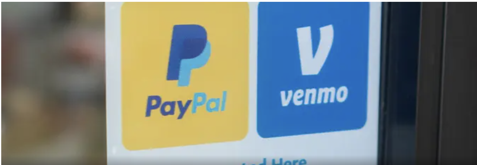 A poster on a glass showing he Venmo and PayPal logos.