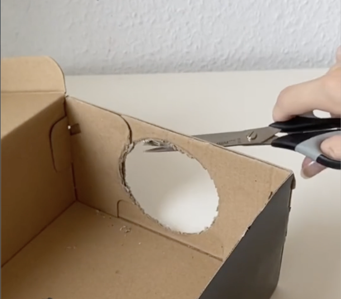 Cutting a hole in a brown box