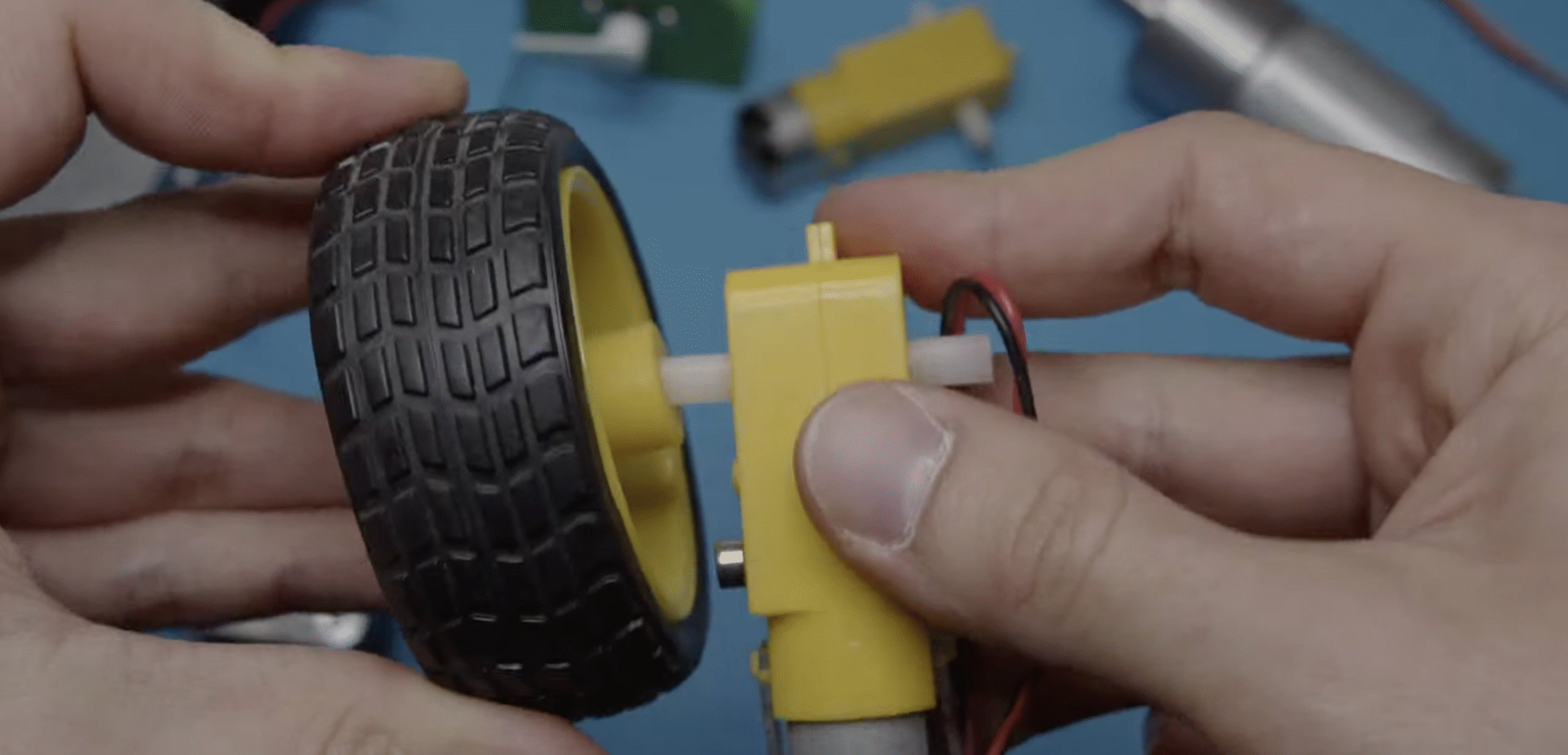Picture of man attaching robot wheel to motor