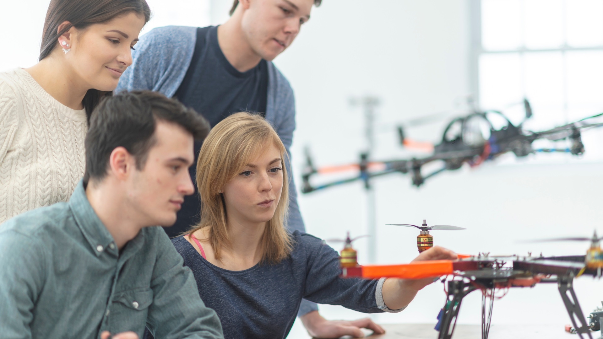 Photo of people gathered a round a drone