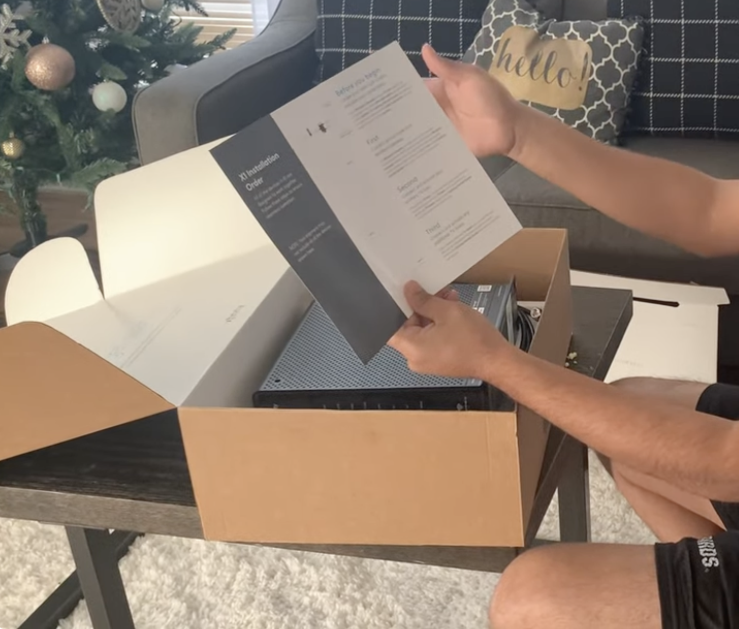 Man unboxing Xfinity WiFi box with cables and documentation laid out on a table.