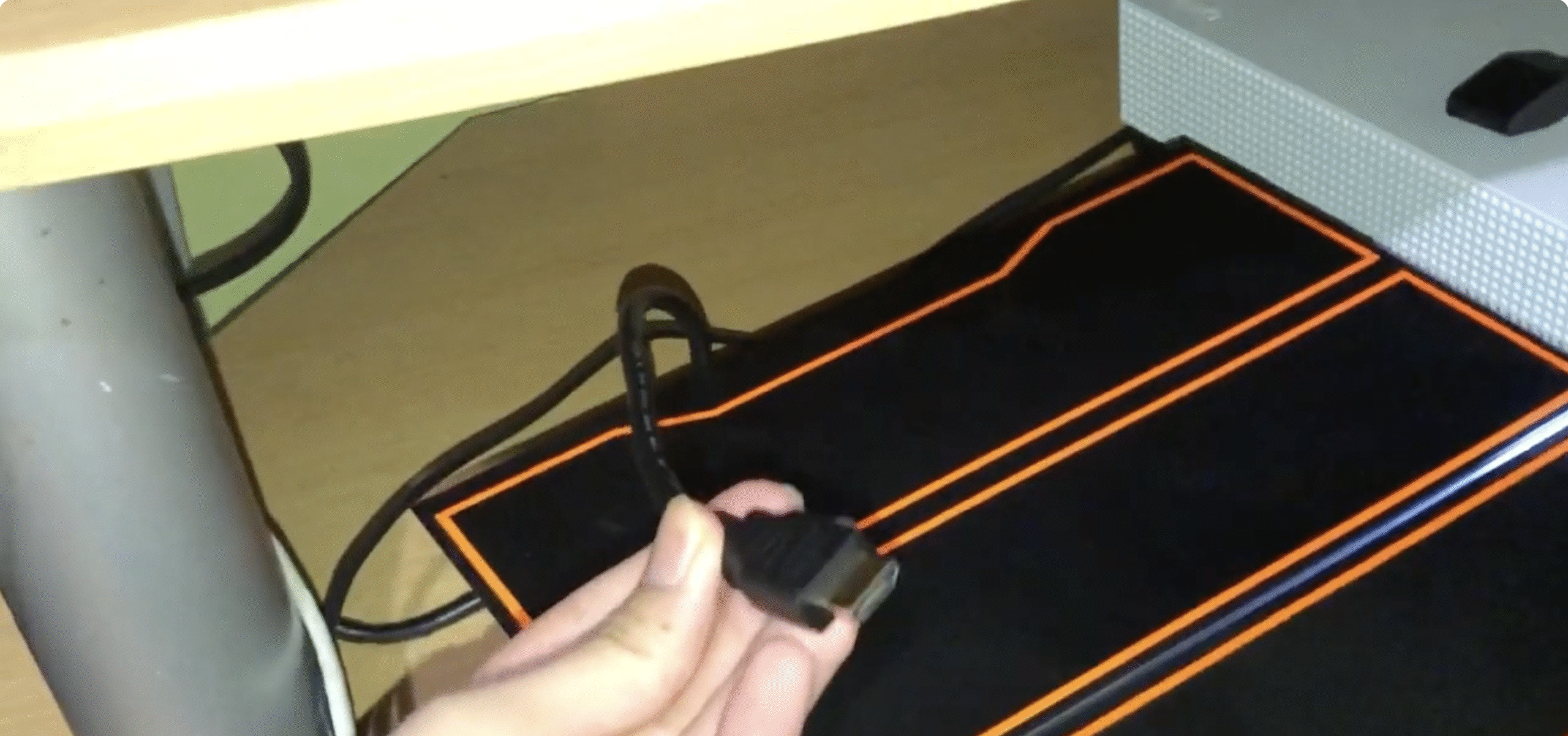User holding HDMI cable next to a PS4 to swap and test for a bad cable.