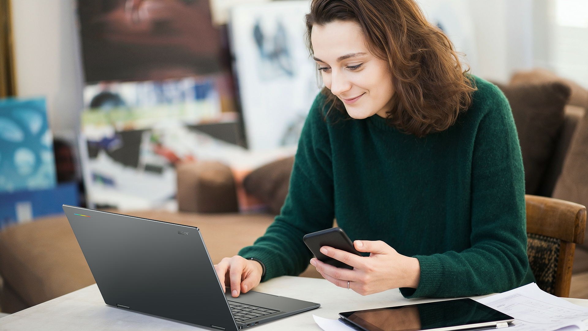 Woman using the Acer Googlebook 14 at a table while holding a phone