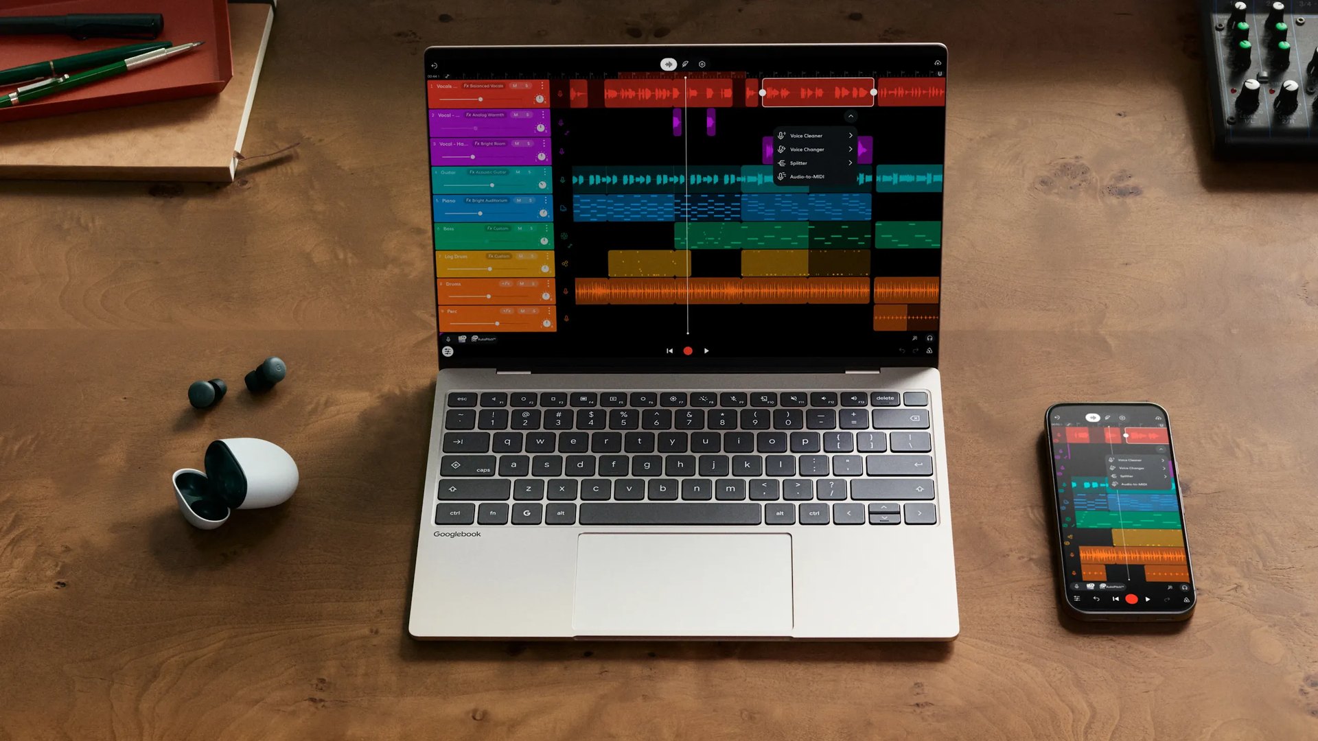 Googlebook laptop next to an Android phone on a wooden desk