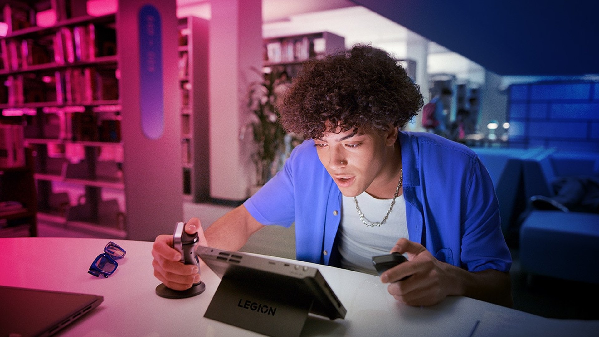 A person using a Lenovo Legion Go handheld on a desk