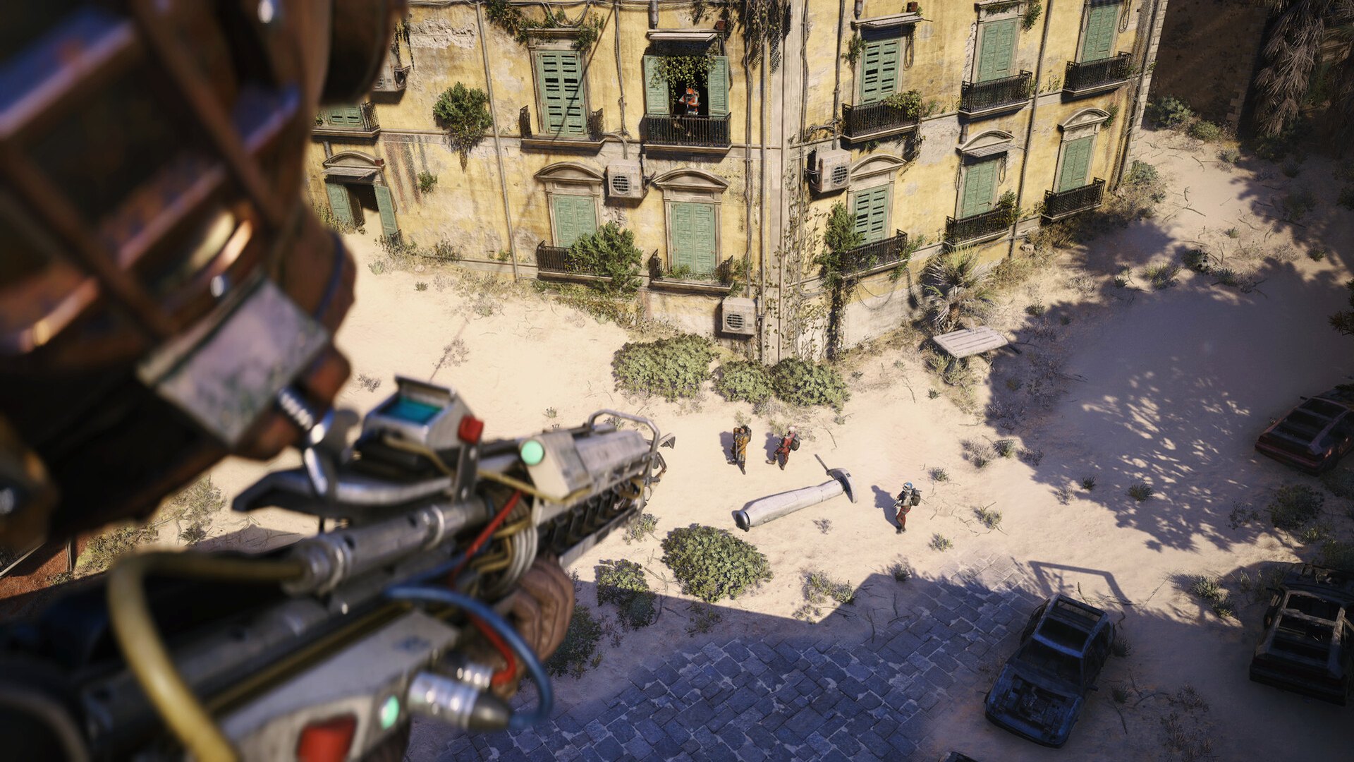 First-person view over a sand-filled piazza and a shuttered apartment block