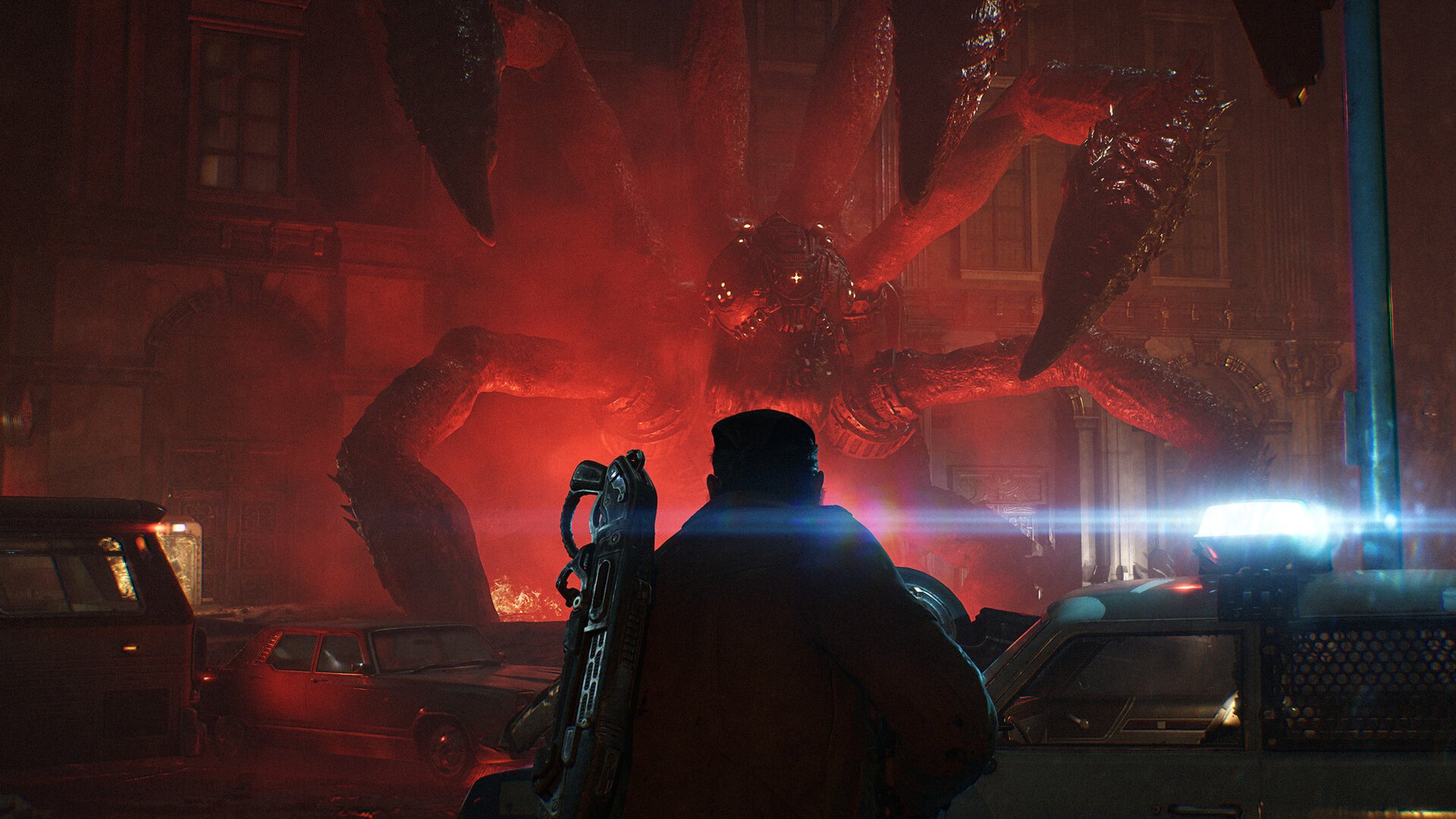 A soldier watches a large creature emerge from a street lit in red