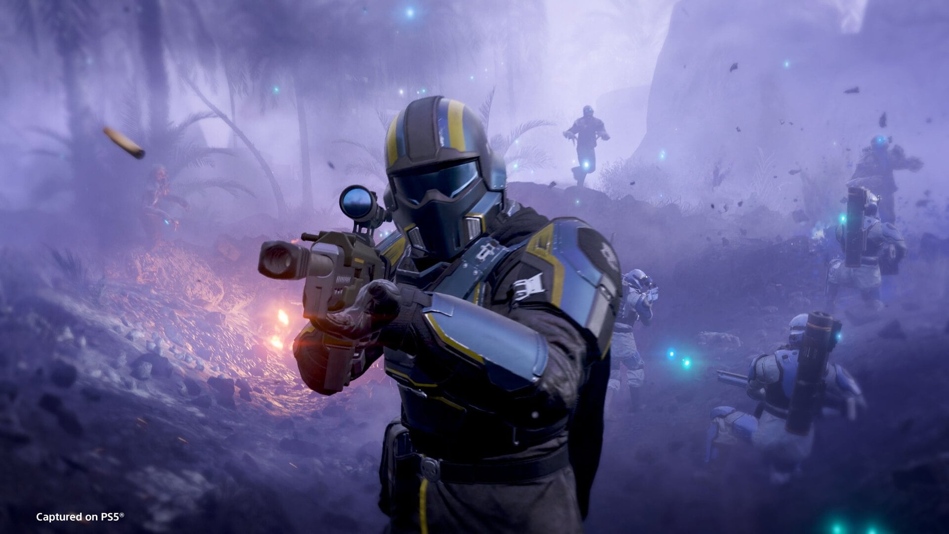 A Helldiver in a yellow-visored helmet aims a rifle in misty woodland