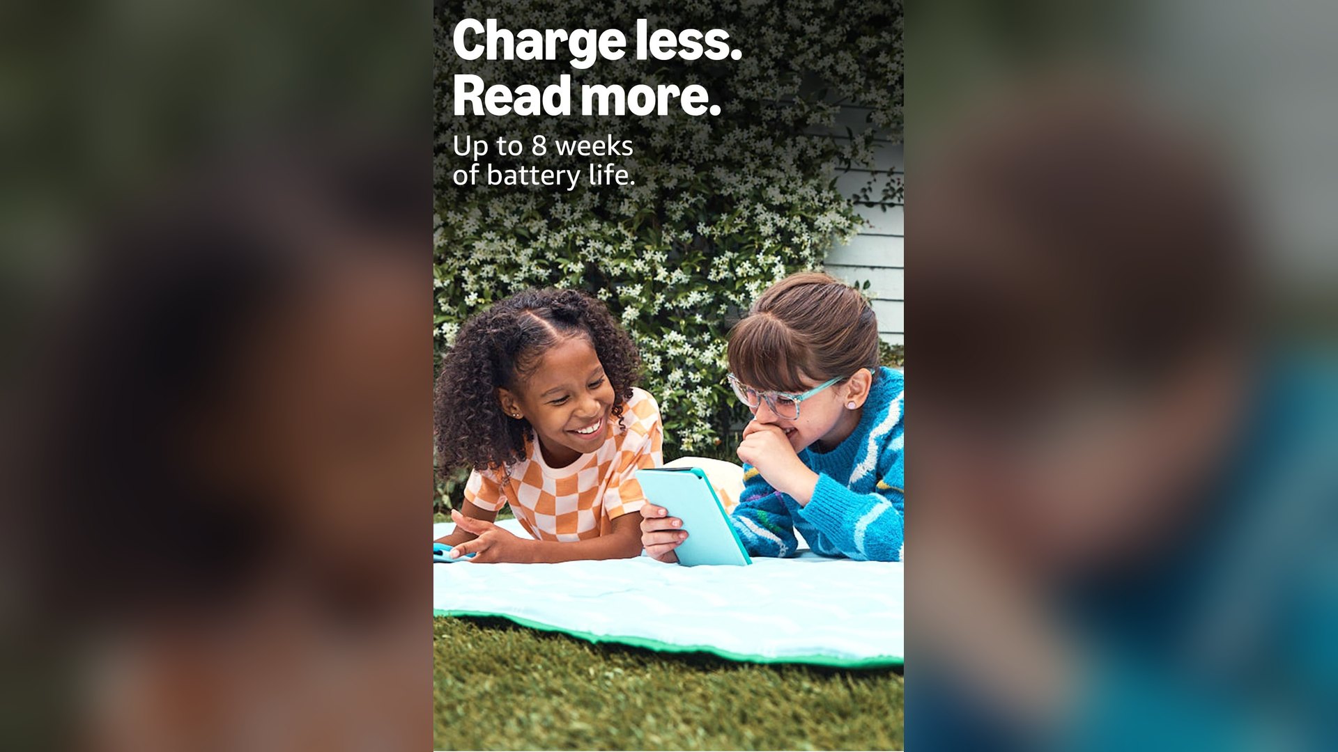 Two children reading a Kindle Colorsoft Kids together on a blanket outdoors