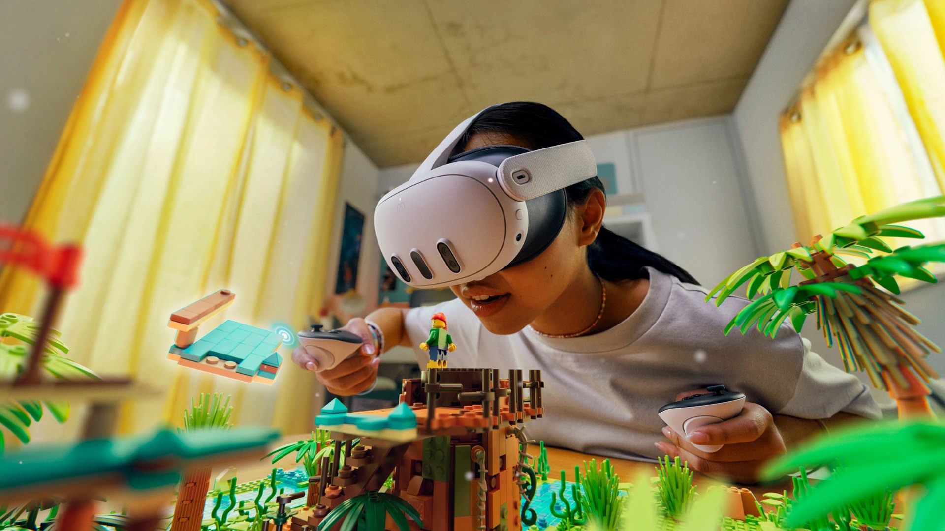 Person wearing a Meta Quest 3 headset and holding two controllers over a toy brick scene
