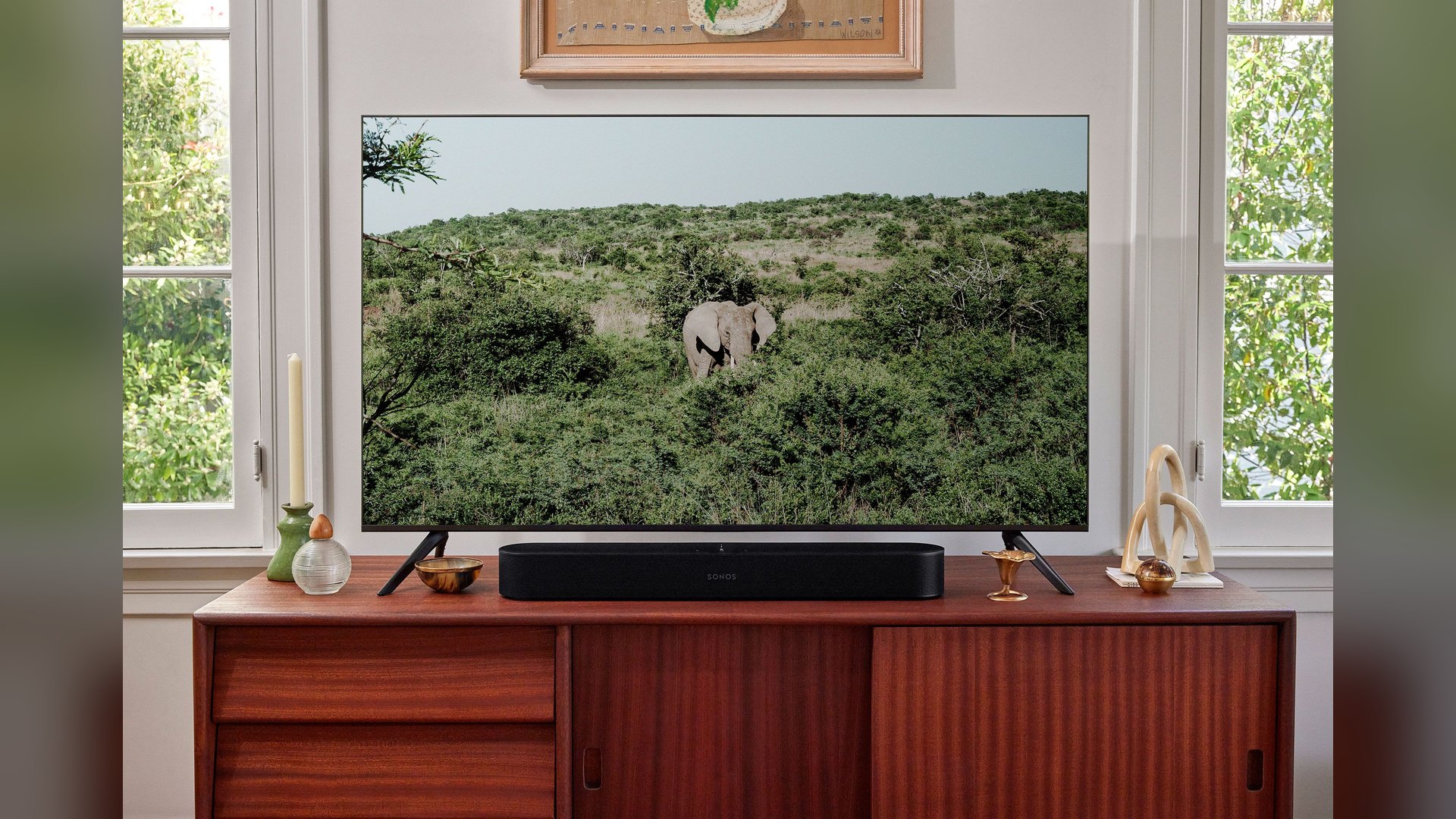 Black Sonos Beam Gen 2 on a wooden credenza beneath a TV