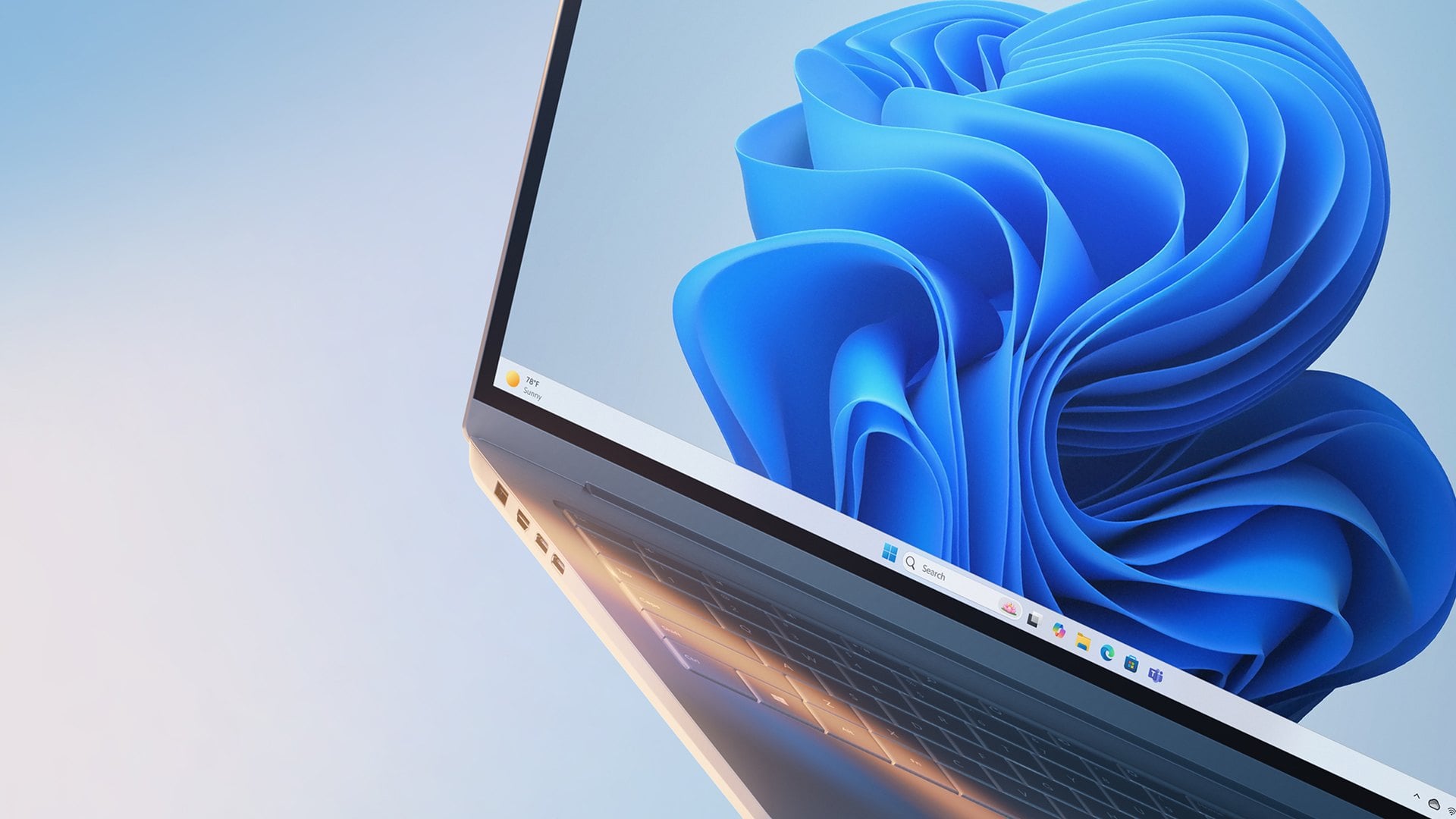 Corner of a laptop screen showing the blue Windows 11 bloom wallpaper