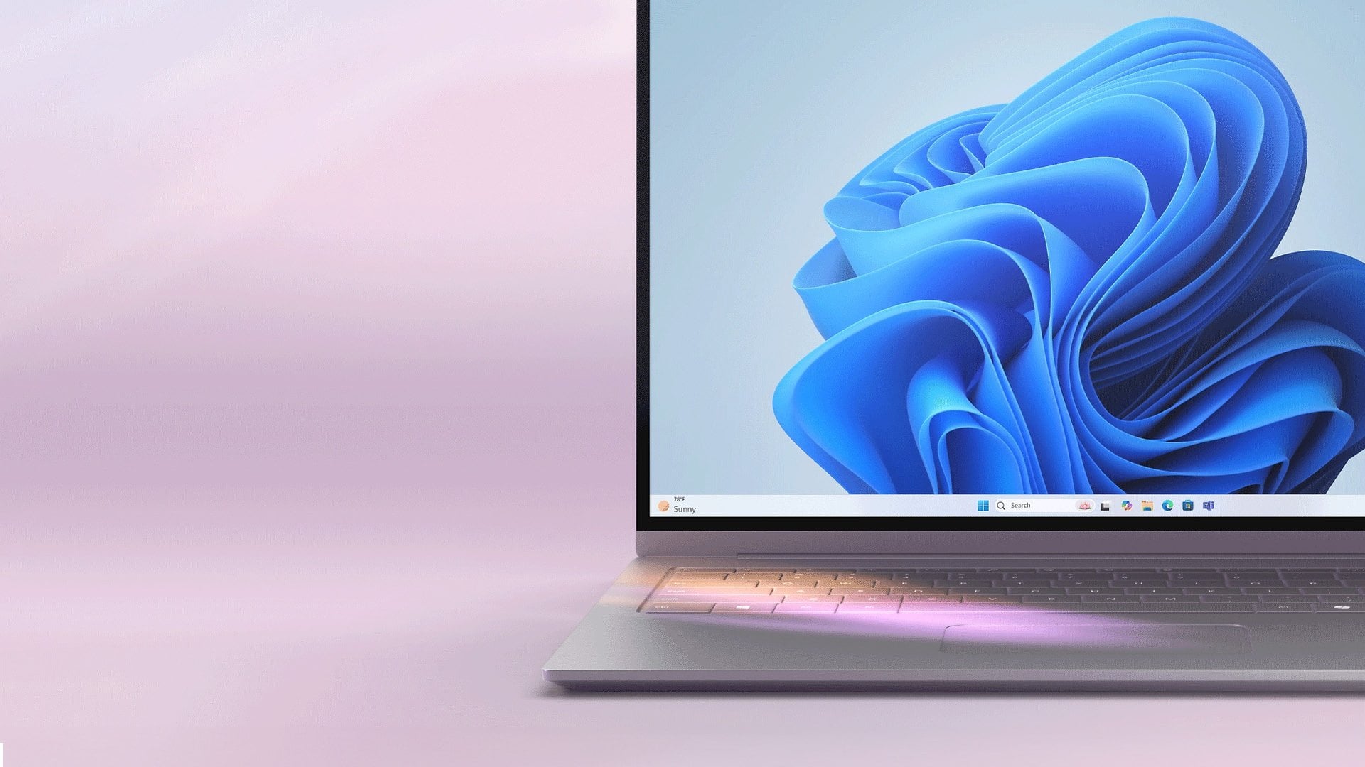 An open laptop on a light purple background showing the blue Windows bloom wallpaper